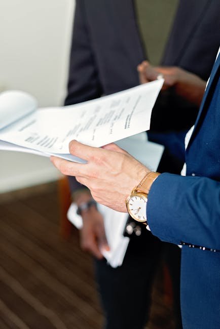 Close-up of professionals reviewing documents in a meeting, focusing on details and teamwork.
